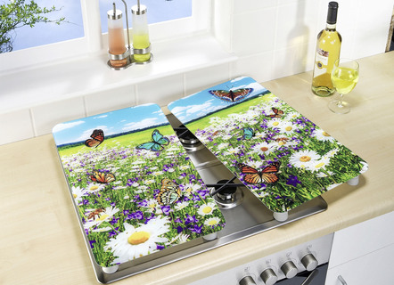 De dekkingsplaten van de kachel die van glas met het motief van de de zomerweide worden gemaakt