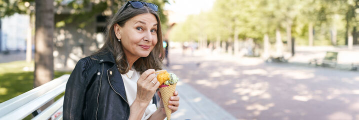 Dame met zonnebril, ijsje en zwart licht leren jasje