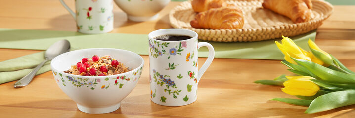 Ontbijtkom met muesli en koffiekopje