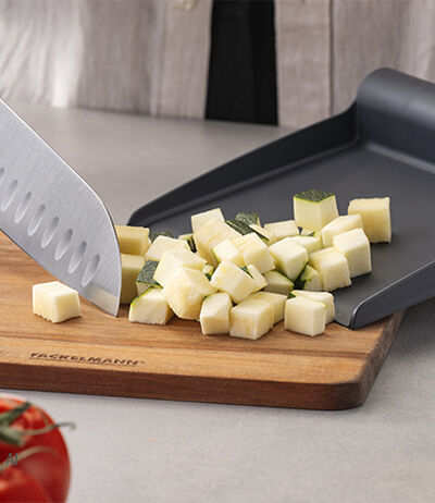 Een oliedispenser giet dressing over een verse salade
