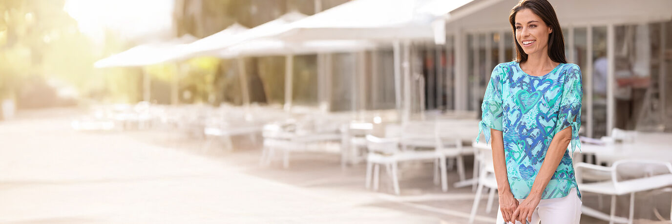 Dame in blauwe shirt-tuniek en witte broek