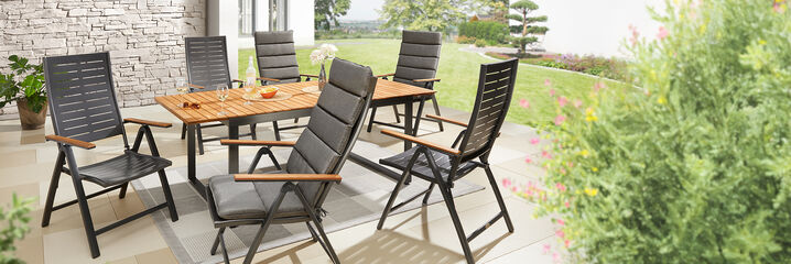 Tuinmeubilair: houten tafel en 6 zwarte tuinstoelen