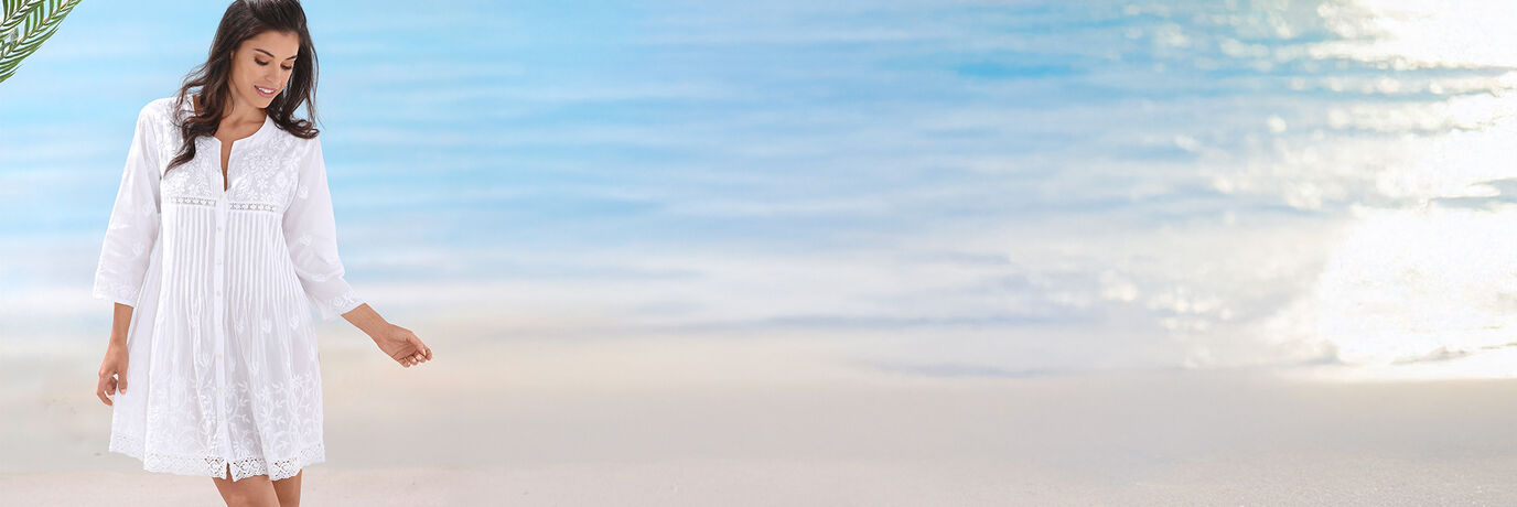 Vrouw in een witte jurk op het strand