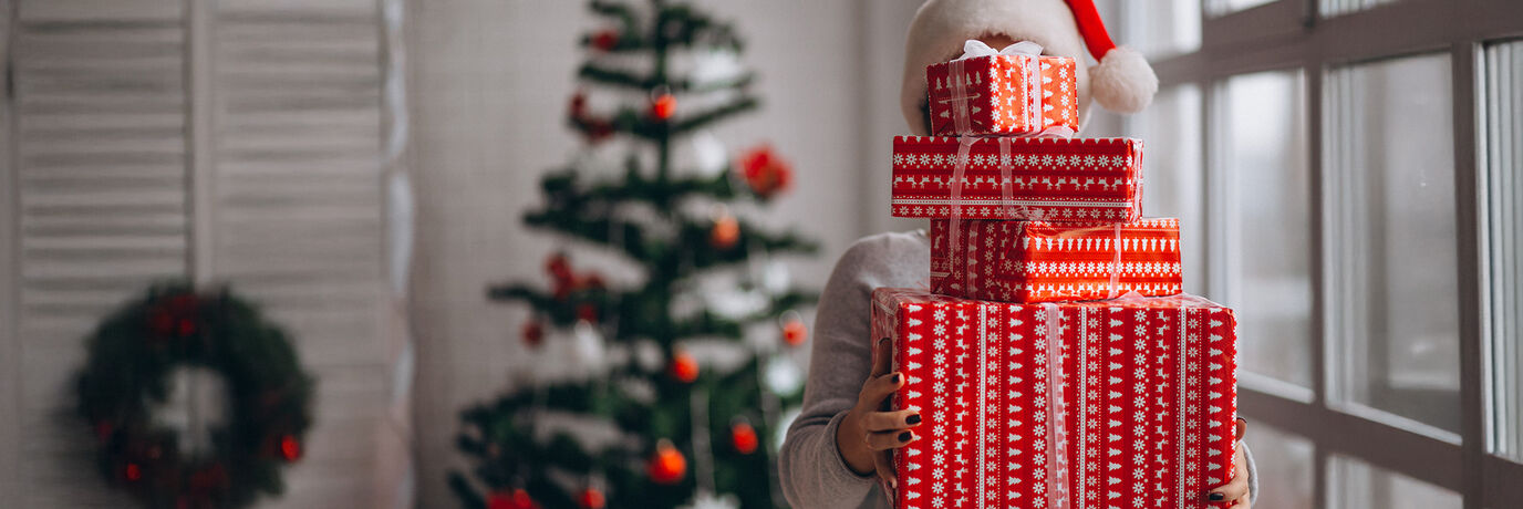 Vrouw met 4 cadeaus en kerstboom