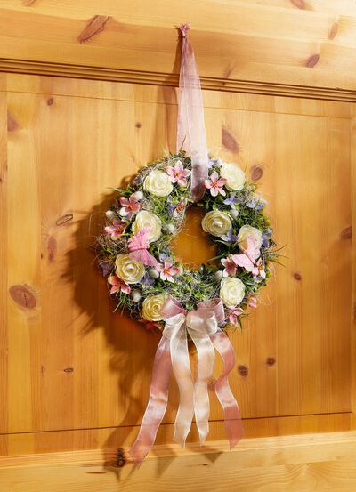 Wandkrans met ranonkels en roze bloemen 