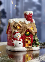 Verlicht huis met sneeuwpop 