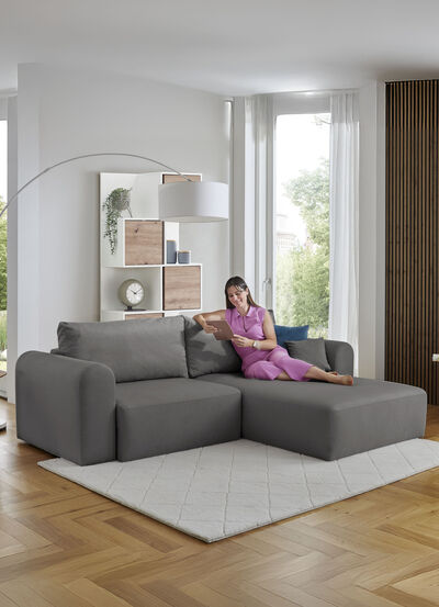 Gestoffeerde hoek met bedfunctie en decoratieve kussens 