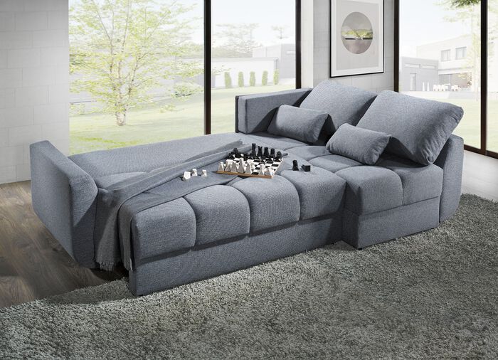 Gestoffeerde hoekbank met slaapfunctie die vrij in de ruimte geplaatst kan worden 