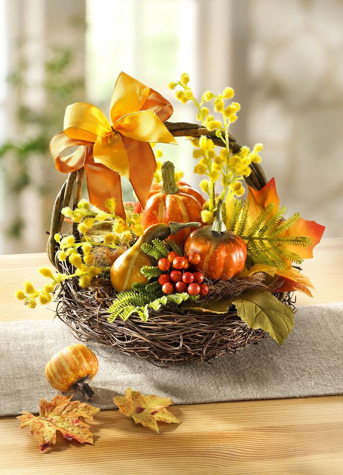 Pompoenarrangement in een mand van kreupelhout 