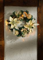 Verlichte dennenkrans met poinsettiabloemen 