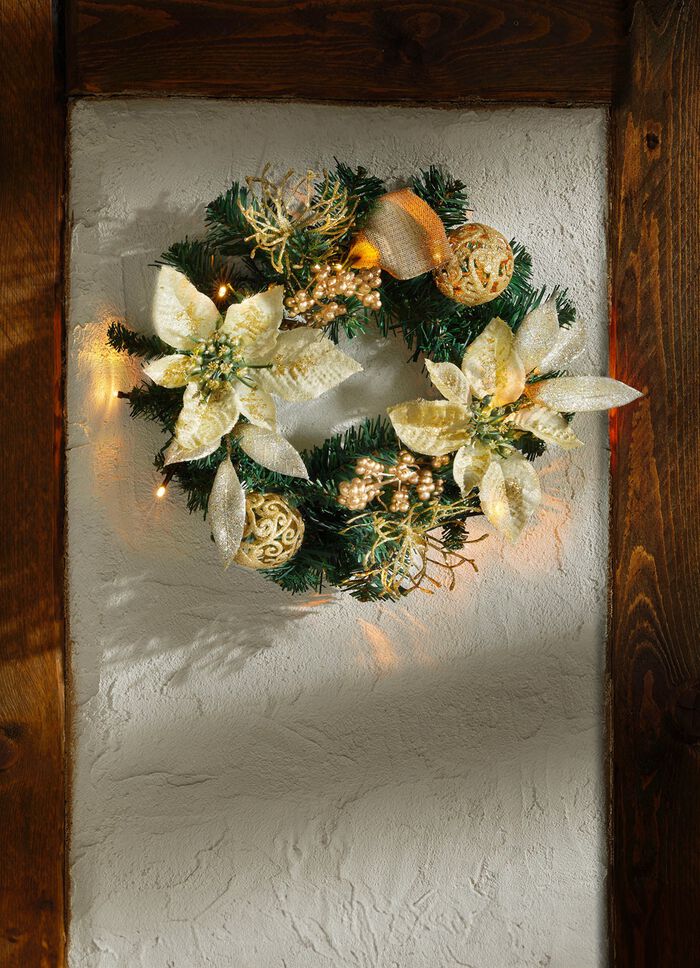 Verlichte dennenkrans met poinsettiabloemen 