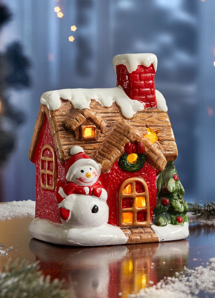 Verlicht huis met sneeuwpop 